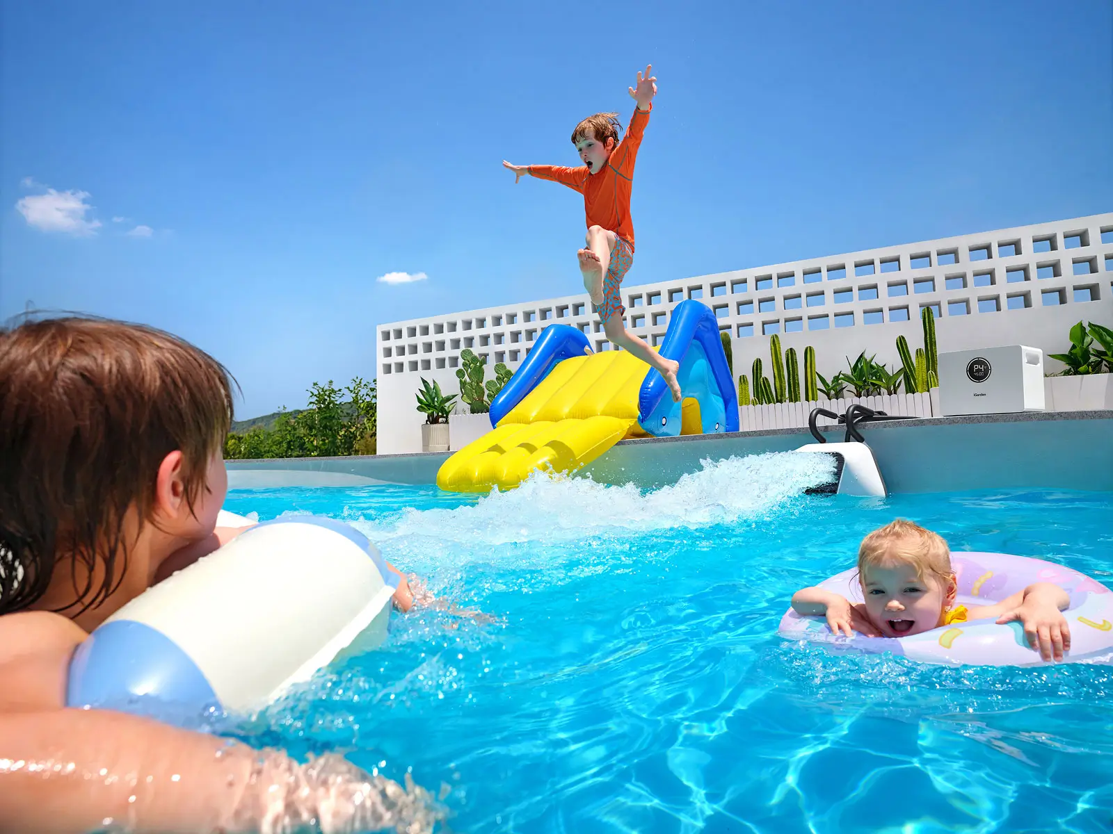 Father and son playing in pool with iGarden portable swim jet